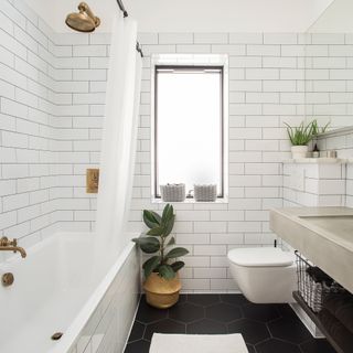 White bathroom with metro tiles and gold shower head