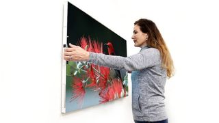 Woman putting large TV on wall