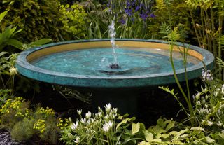low level garden fountain in verdigris saucer