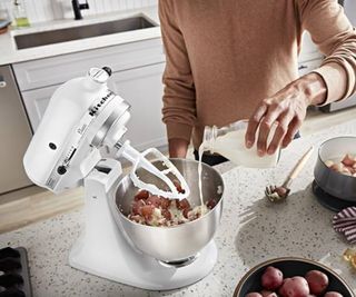 KitchenAid Classic Series Stand Mixer in white on a countertop, making an apple cake