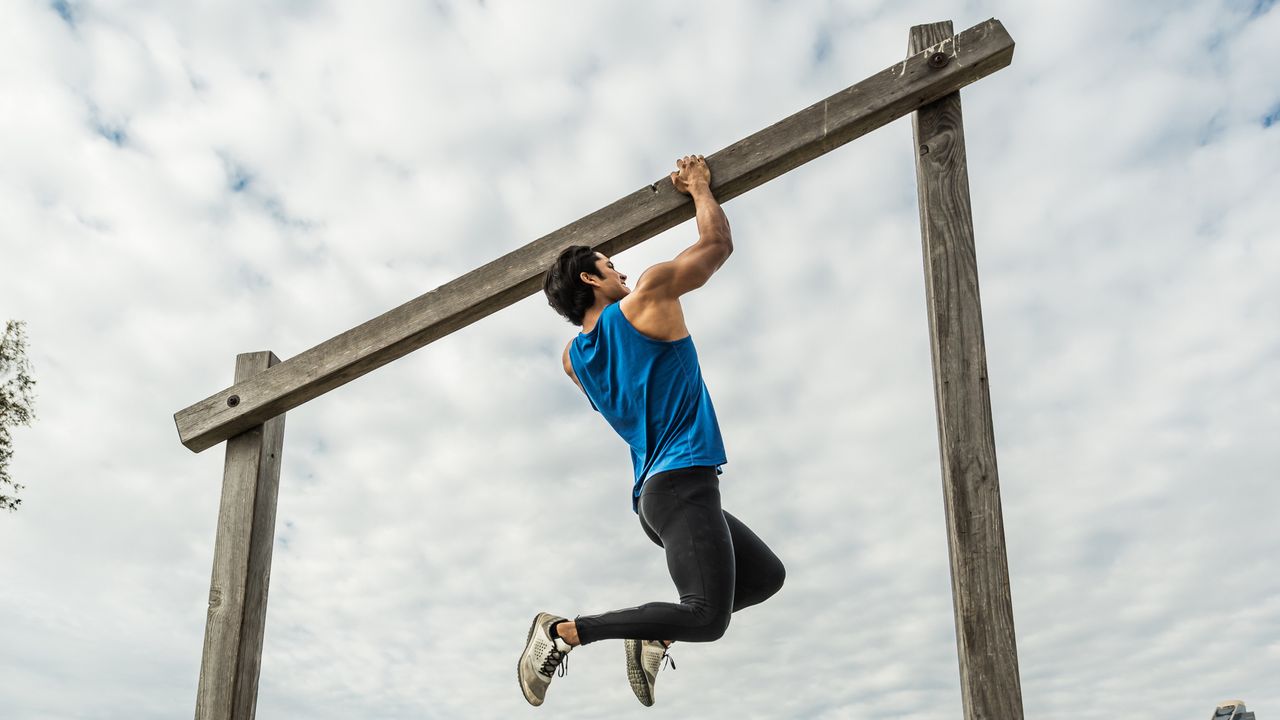 A young Hispanic man working out on a Urban Fitness Training Course