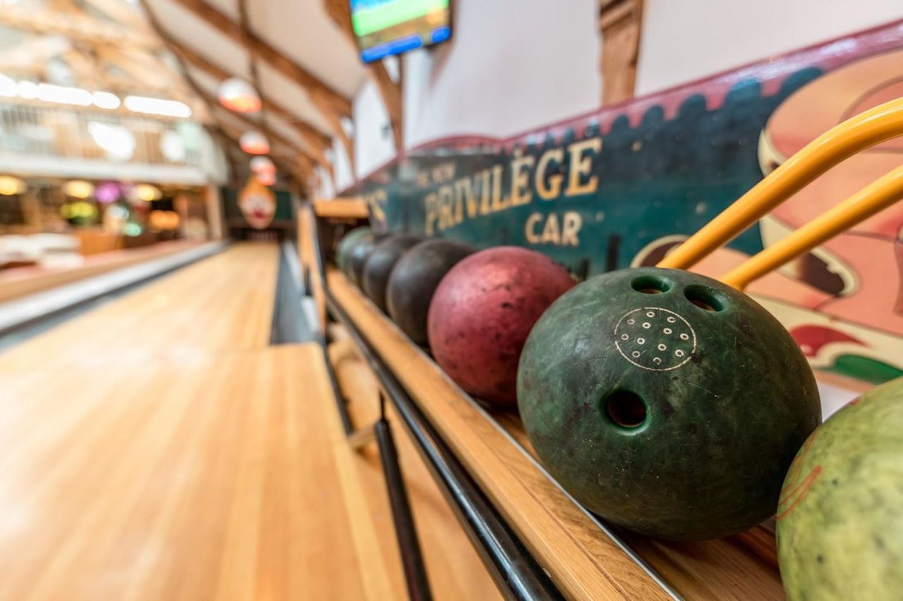 Bowling balls on a shelf with wooden flooring underneath