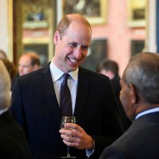 Prince William with a drink in hand at a reception