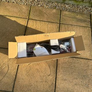 Gtech HeatWave Patio Heater in opened cardboard box with plastic and polystyrene packaging on patio in garden