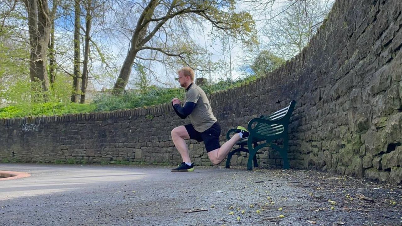 Fit&amp;Well writer Harry Bullmore performing a rear-foot elevated split squat in a park