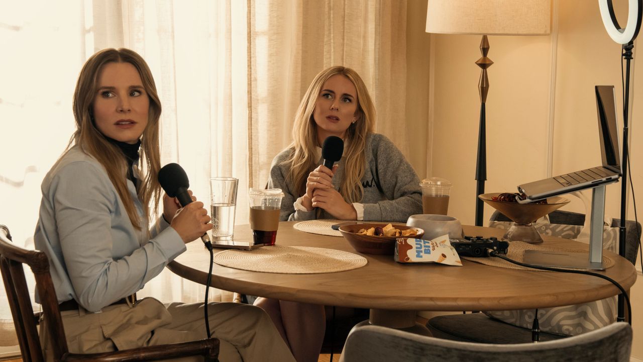 L-R: Joanne (Kristen Bell) and Morgan (Justine Lupe) sit at a table recording a podcast in a scene from "Nobody Wants This" season 2