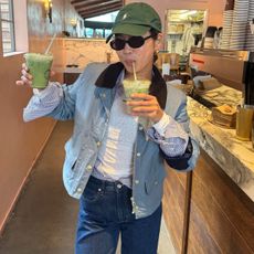 Woman in tank top, barn jacket, and jeans