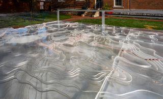 Calibrate, Natalie Yates, 2021. An outdoor architectural exhibit of a topographical map made from clear plastic.