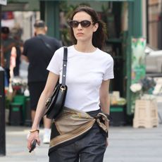 Alexa Chung wears a white t-shirt, denim jeans, scarf and black Gucci horsebit bag