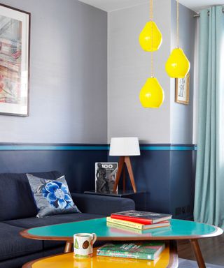 Blue living room with coffee tables table lamp and yellow pendant light