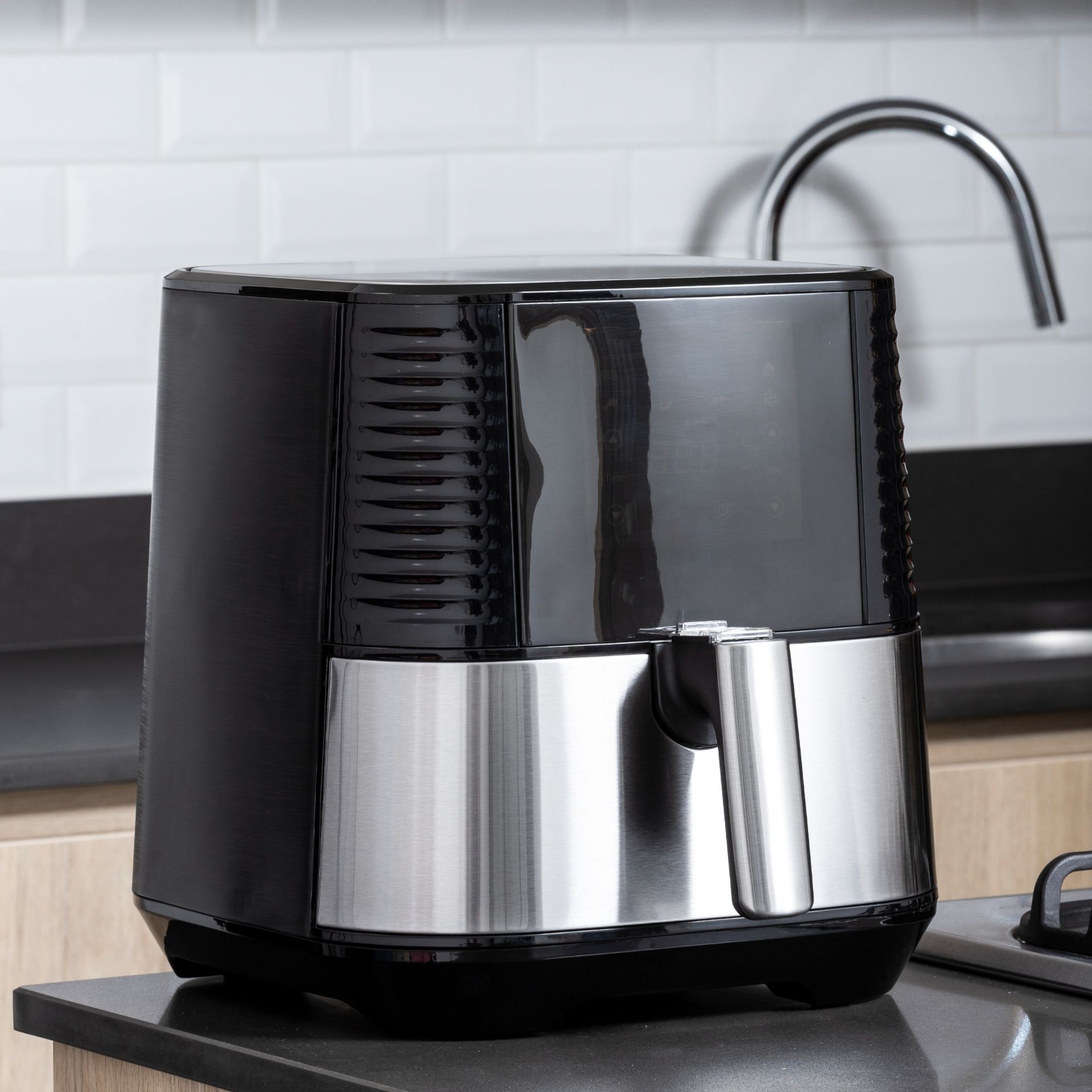 Black and silver single basket air fryer on kitchen worktop