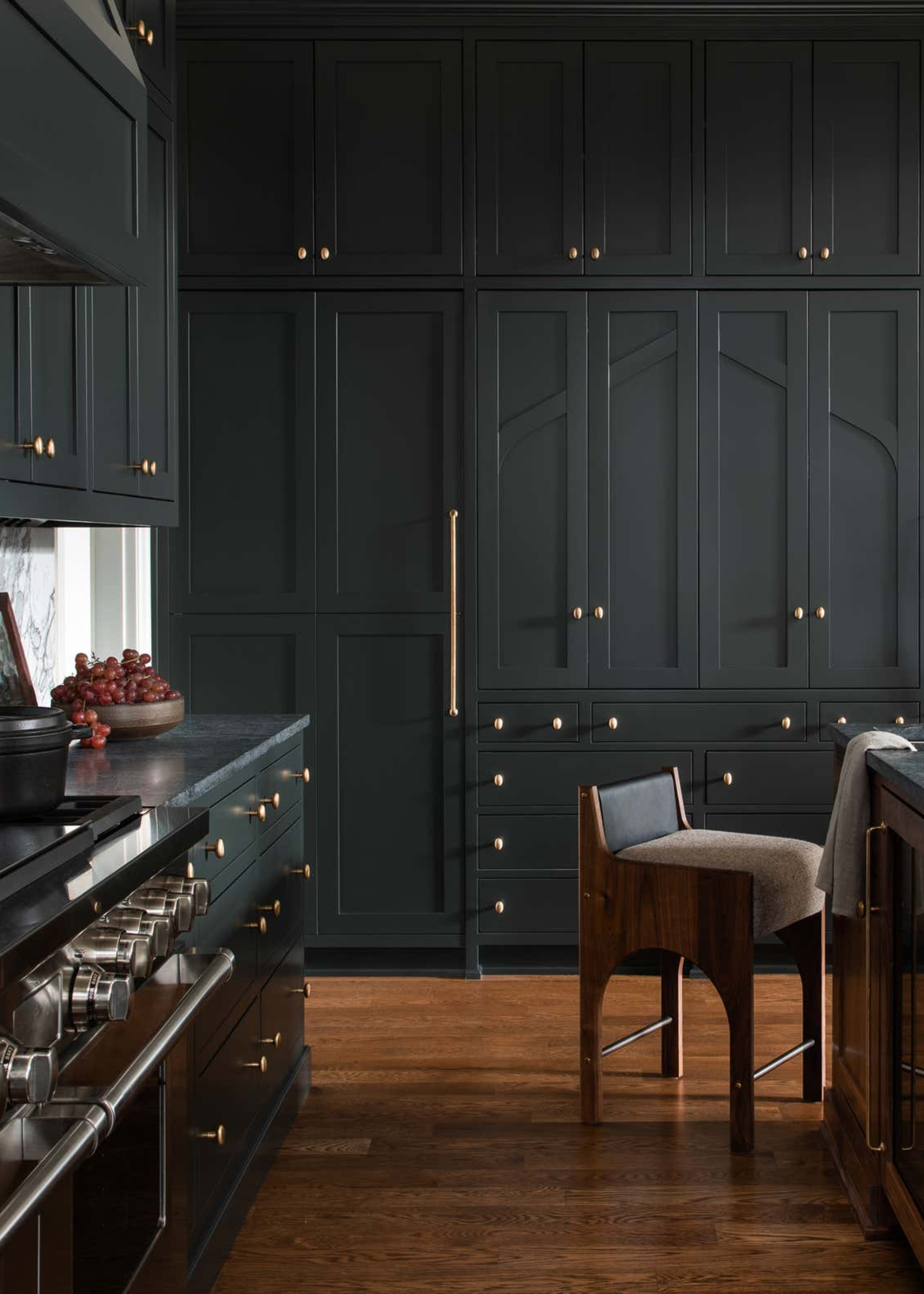 A dark grey shaker style kitchen with bar stool and a range cooker