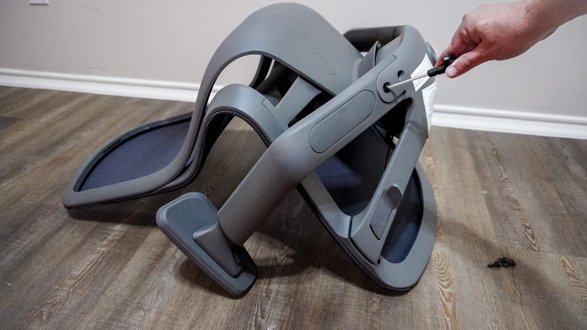 A person putting together the Branch Aire Chair using an Allen wrench