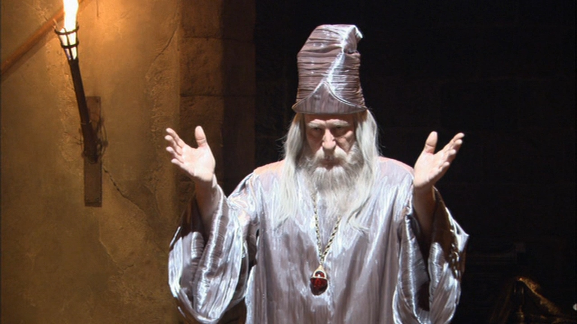 Screenshot from Stargate SG-1 showing a man in a wizard outfit.