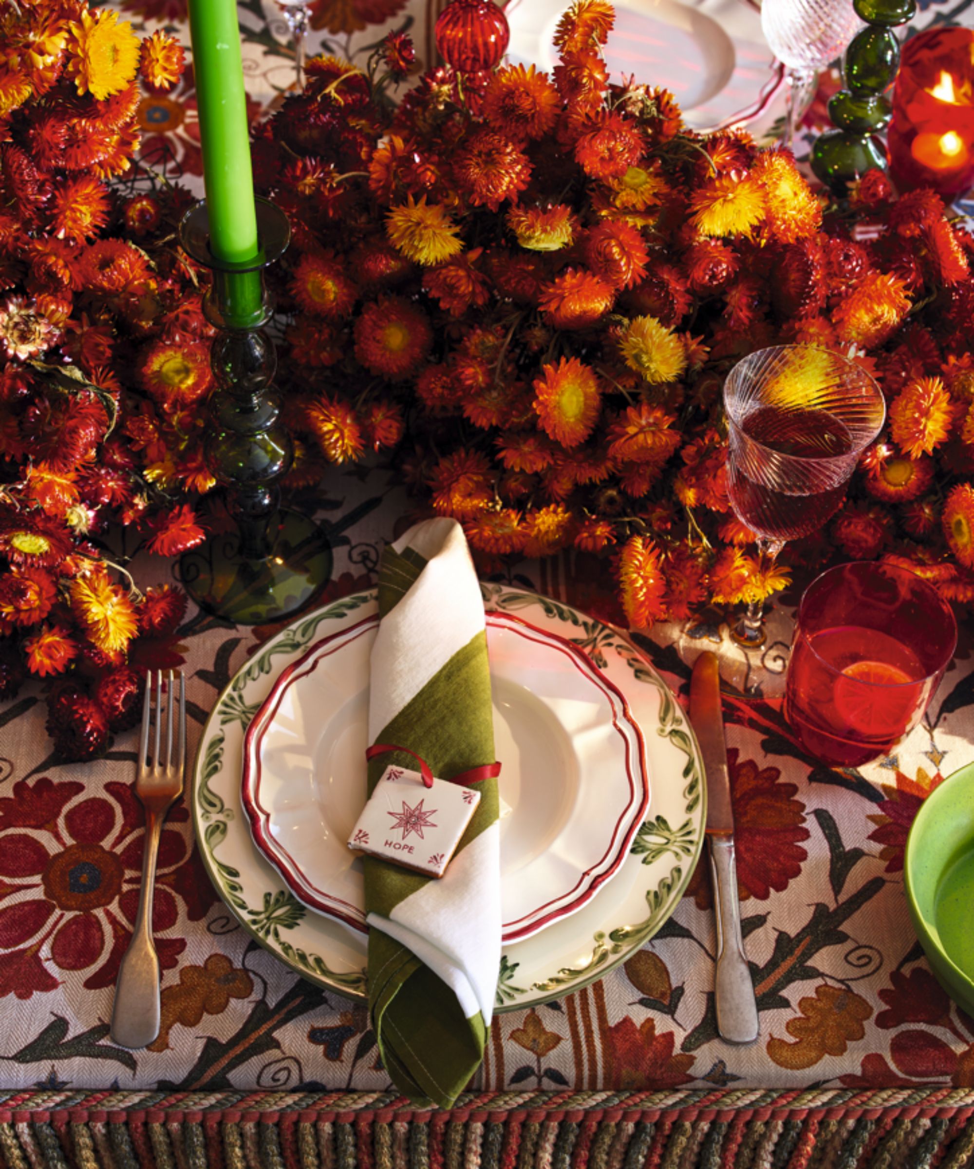 Red floral tablecloth with red and yellow marigold centerpiece