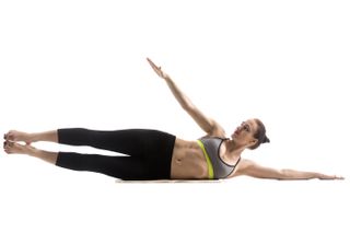 Woman doing one of the best ab exercises, oblique leg lifts