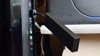 The Amazon Fire TV Stick plugged into a TV's HDMI port.