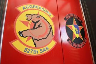The 527th Space Aggressors Squadron and 26th Space Aggressors Squadron emblems are painted side by side on doors inside the Space Aggressors' facility at Schriever Air Force Base, Colorado.