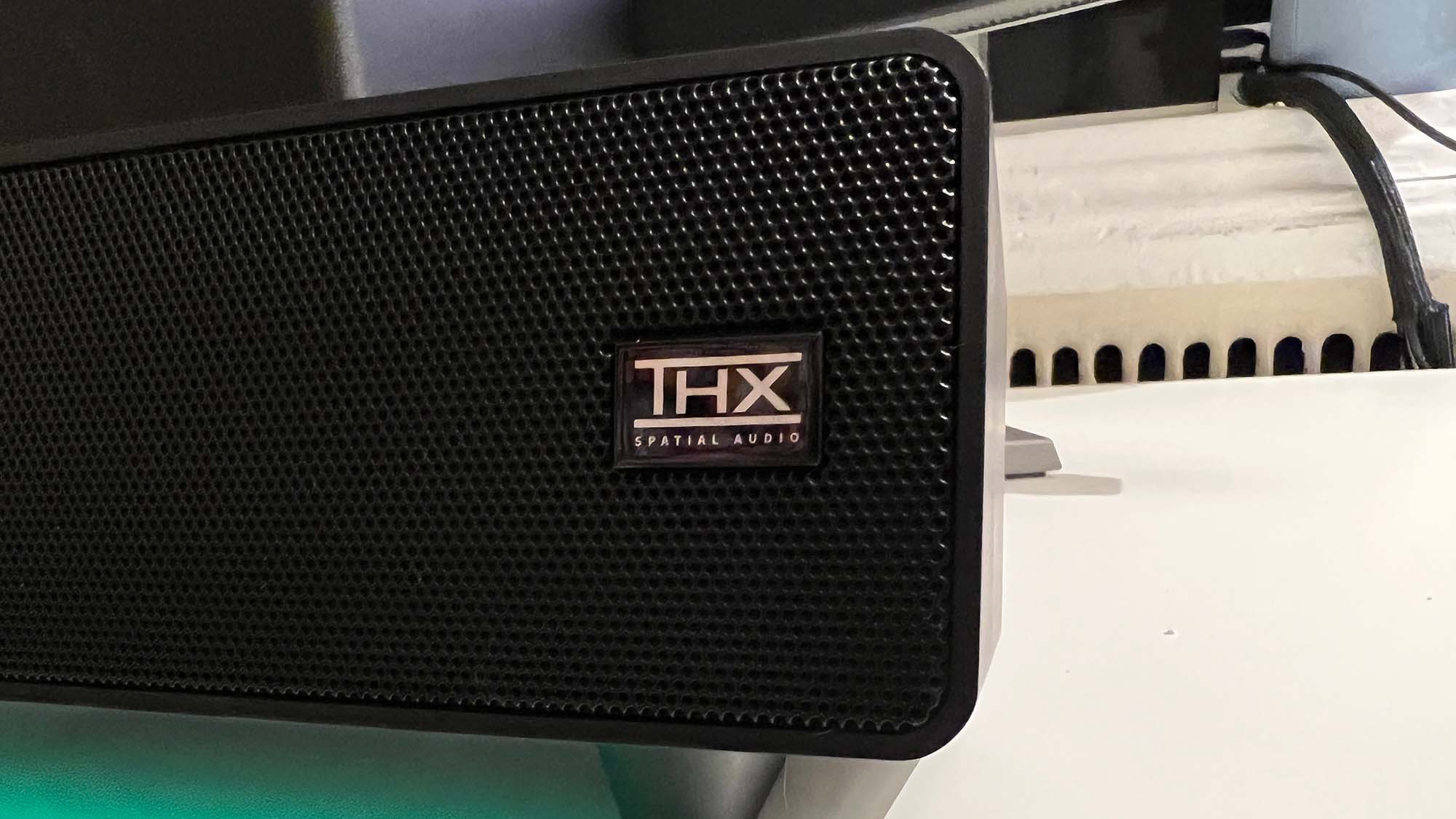 O emblema THX Spatial Audio na frente de uma barra de som Razer Leviathan V2
