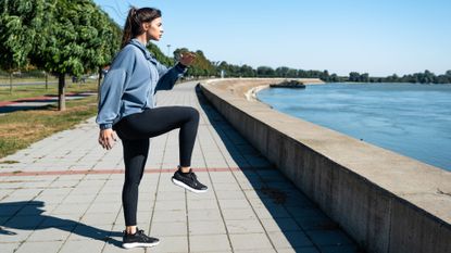 A woman doing high knees as part of an outdoor workout