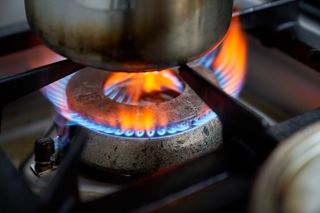 Gas ring on a hob with a pan being heated over the top