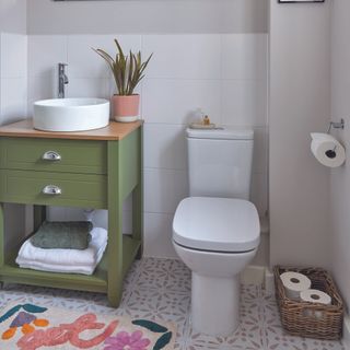 Bathroom with toilet and green storage unit