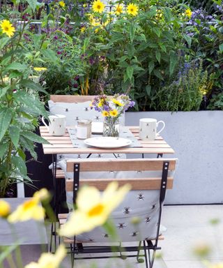 balcony garden with planters and bistro set