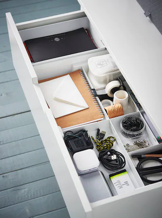 A white drawer in a home office with drawer dividers to segment stationery