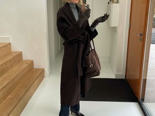 Anouk Yve in a brown coat and The Row Margaux Bag