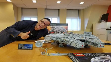 Our Editor-In-Chief, Tariq Malik, is posing with a smile and a thumbs up next to a large, brick-built spaceship