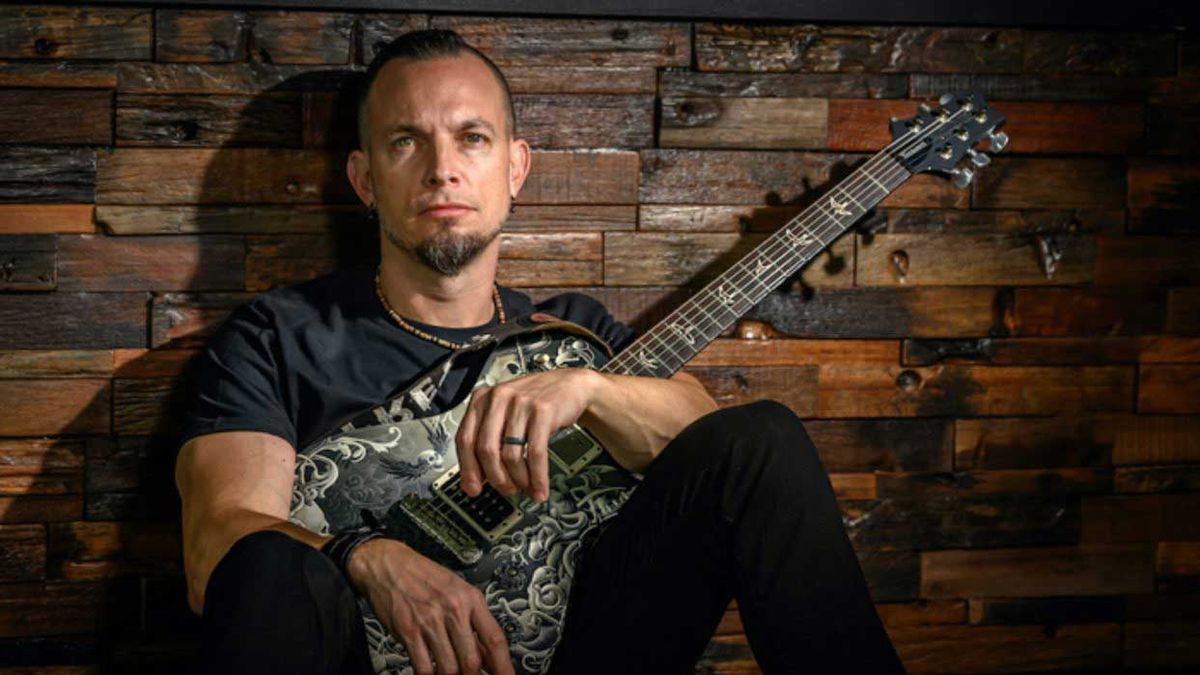 Mark Tremonti sitting down withy a guitar