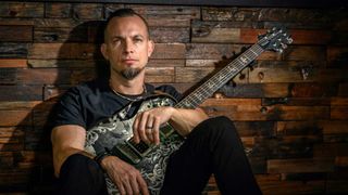 Mark Tremonti sitting down withy a guitar