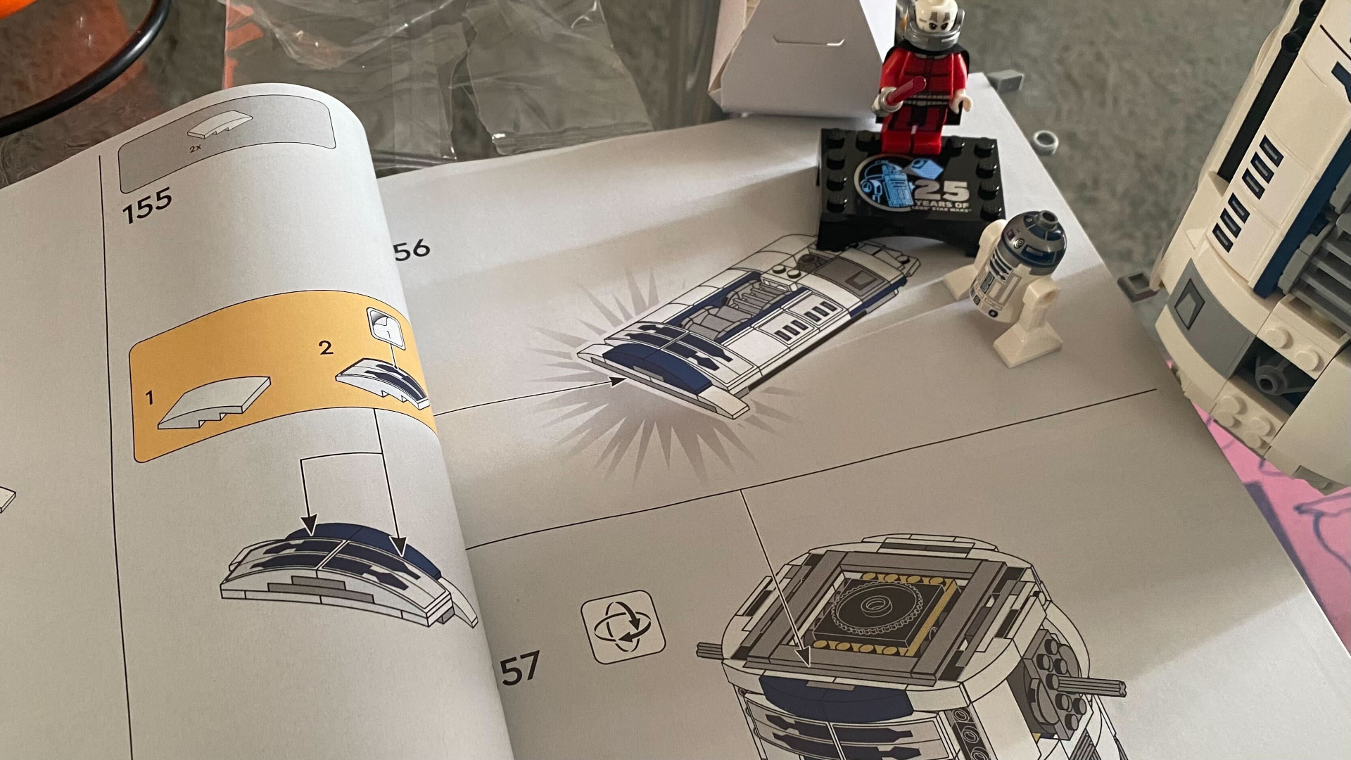 Lego R2-D2 instruction booklet with minifigures laid out on top of it