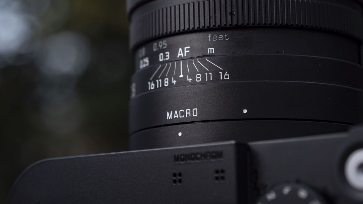 Leica Q3 Monochrom compact camera outside on a snow-dusted log
