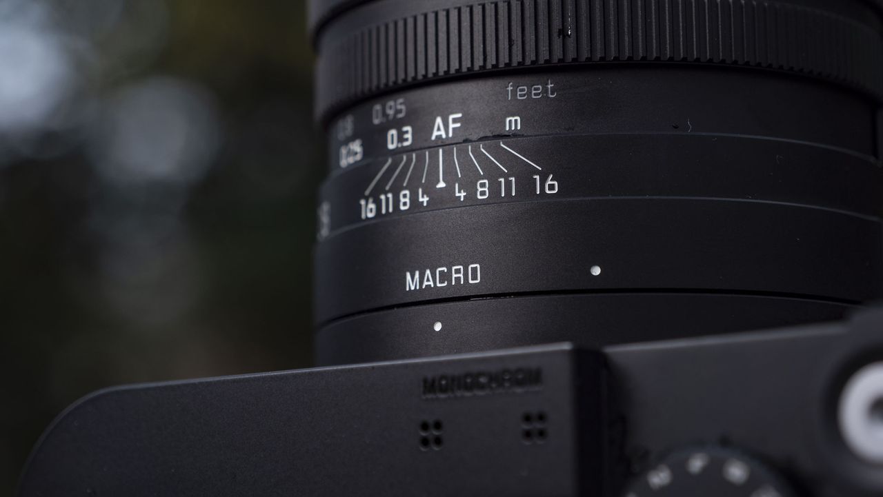 Leica Q3 Monochrom compact camera outside on a snow-dusted log