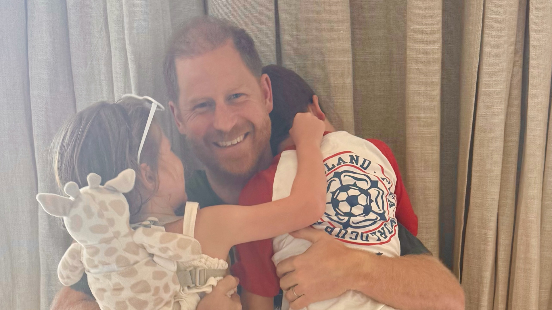 Prince Archie and Princess Lilibet hugging Prince Harry