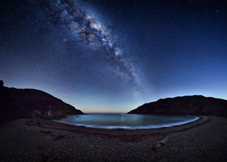 The magnificent Milky Way stretches across the night sky reflecting on the Cable Bay near Nelson, New Zealand. Image: Mark Gee