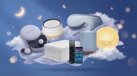 Against a purple and blue background with moon and stars, from left to right: the NextSense SmartBuds in their case, a BrownNoise white noise machine, the BedJet Cooling system with its app and remote, the Bob and Brad eye massage, an Asakuki oil diffuser, and a Jall sunrise alarm clock