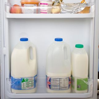open fridge door with milk bottles