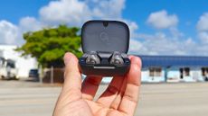 Anker Soundcore C30i in charging case held up against a blue sky