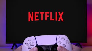Netflix logo at TV screen with man holding game controller.