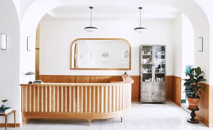 Tilden Hotel reception area with brown wooden corner desk and white and brown walls