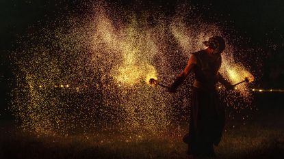 A man is showered in embers during a fire performance as part of the autumn equinox celebrations in Vilnius, Lithuania