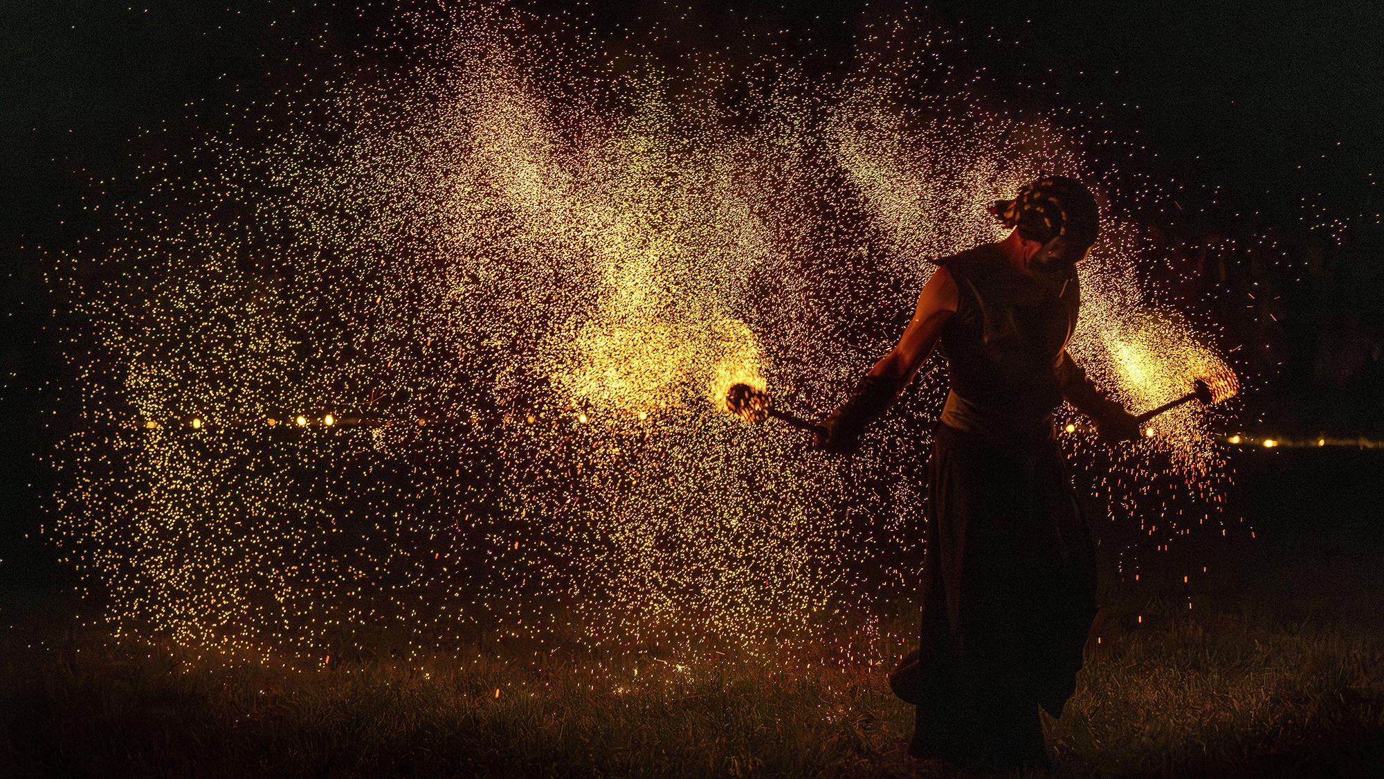 A man is showered in embers during a fire performance as part of the autumn equinox celebrations in Vilnius, Lithuania