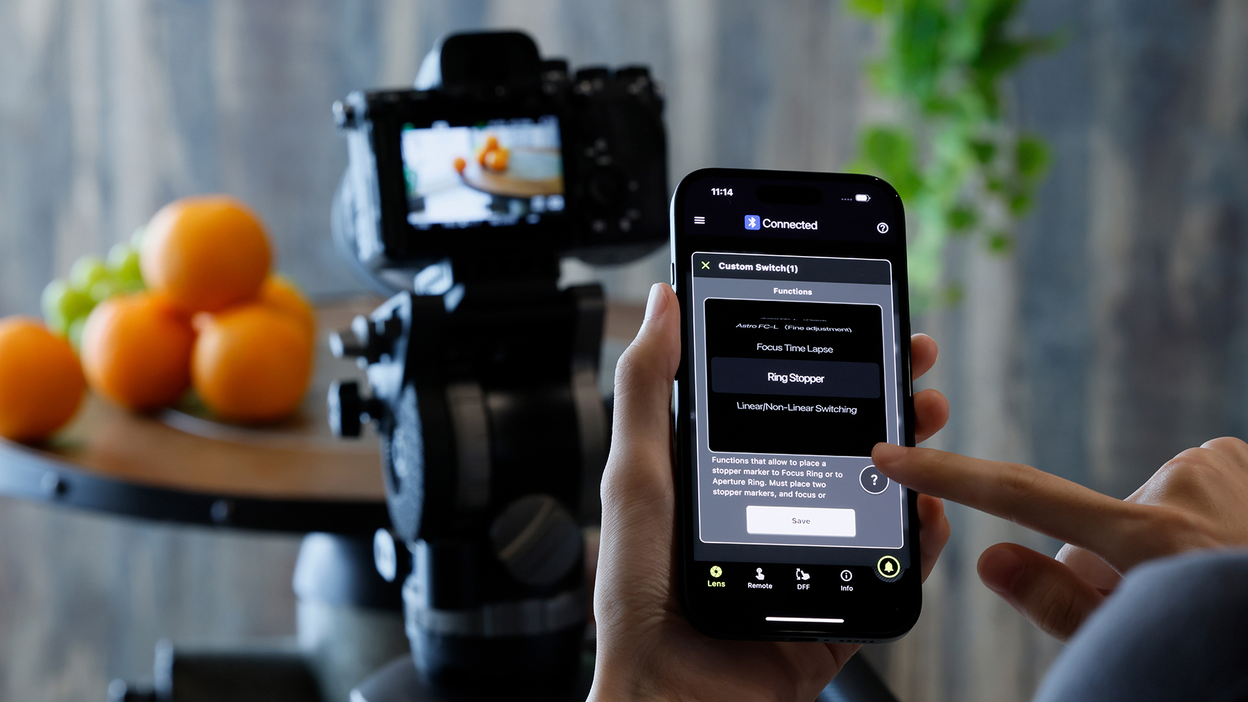The Tamron mobile app with a camera in the background