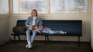 Joan sits on a bench with daughter Kelly in her lap