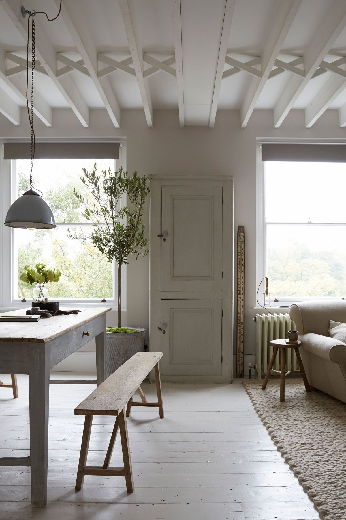 Open plan living and dining room with rustic wooden dining table and bench