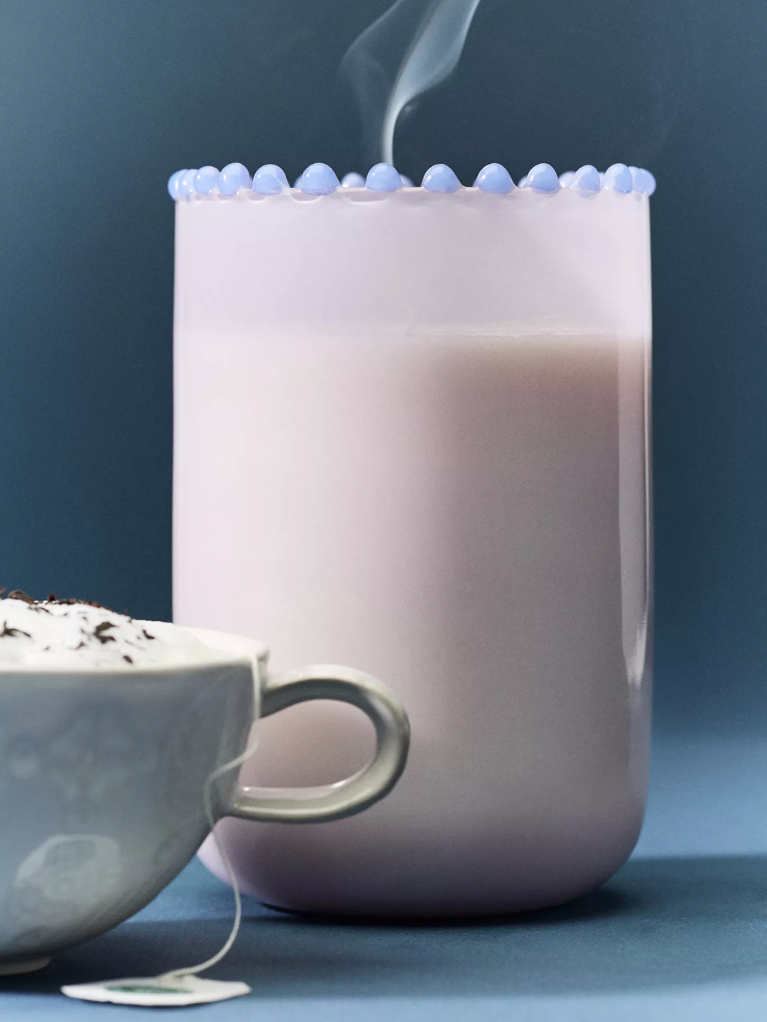 A glass dotted rim lilac candle with an earl gray scent from Anthropologie