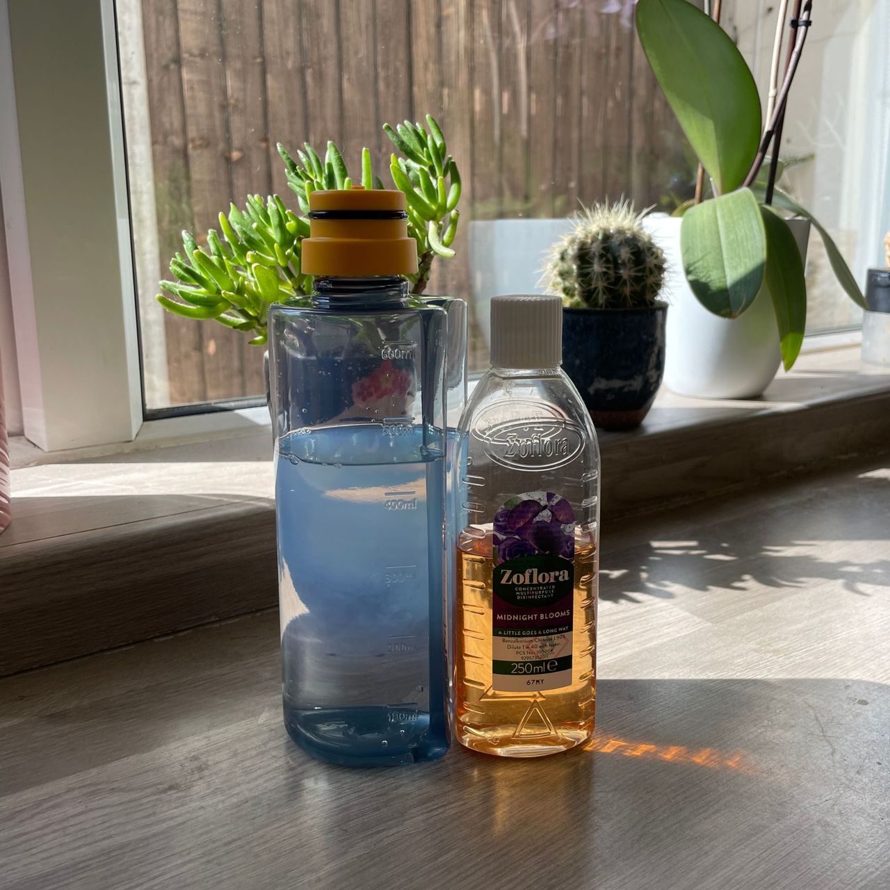 Joseph Joseph spray mop bottle sitting next to a bottle of zoflora on a kitchen worktop