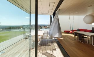 Indoor and outdoor living are seamlessly blended through the architecture of the house and the floor to ceiling glazing